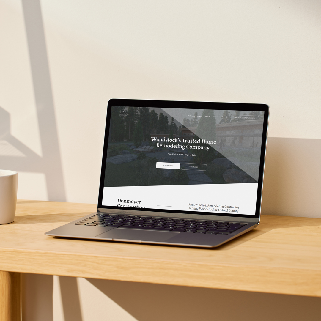 Donmoyer Construction website shown on a laptop in a warm interior