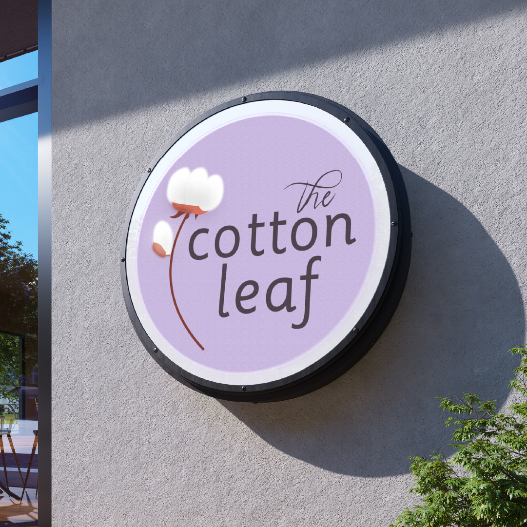The Cotton Leaf circular logo sign mounted on an exterior wall