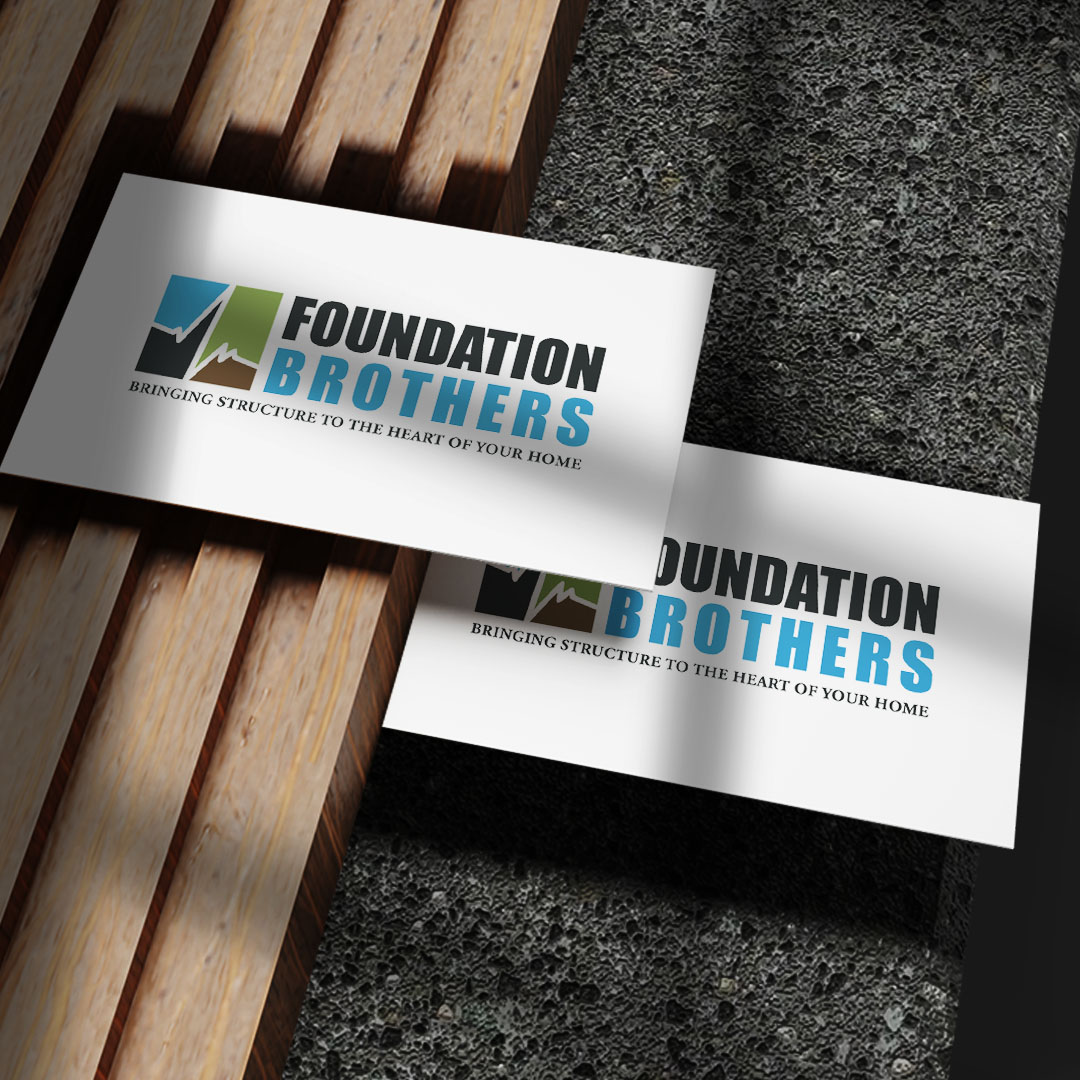 Foundation Brothers business cards on a wood and stone surface